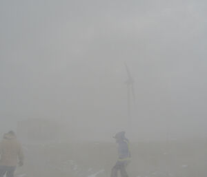 Two expeditioners heading down to the main power house at Mawson during a blizzard