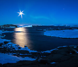 A faint glimmer of an aurora in the sky with the full moon