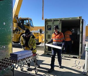 Two expeditioners are unloading boxes of fresh salmon from a shipping container