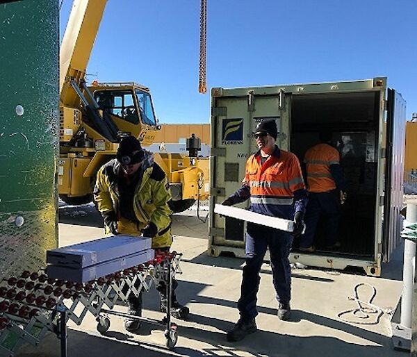 Two expeditioners are unloading boxes of fresh salmon from a shipping container