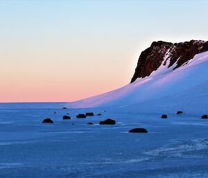 a pink and blue sunset over a field of ice