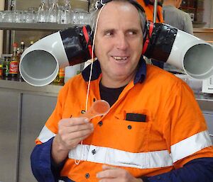 a man wears a set of ear phones made from plumbing pipe