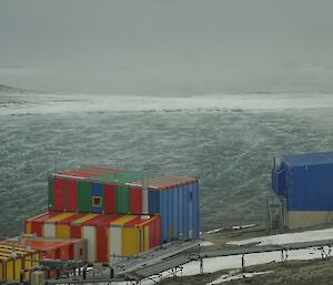wind is blowing in a harbour with 5 colourful buildings in the foreground