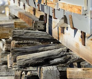 a series of old timber beams are lined up supporting a building