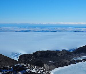 an ice covered plateau leads to the coastline where sea ice formation can be seen