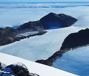 a view of two parallel mountain ranges and the coastline in the distance