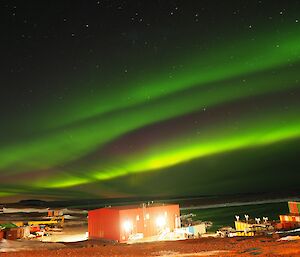 A purple and green banded Aurora over Mawson’s red shed and Horseshoe Harbour