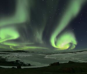 Spirals of white and green over an icy harbour