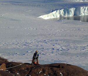 A man starting to descend down a hill with a patient.