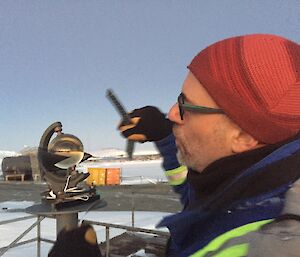 A man swaps out the daily sunshine card using the Campbell Stokes Recorder