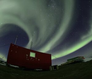 Circular white and green swirls above a red building