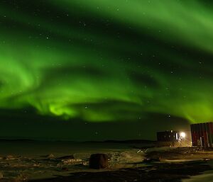 A green aurora behind a red building