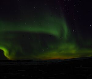 Orange and green flames seem to be rising from the black horizon