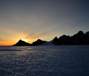 The sun rises behind the peaks of the Masson Ranges