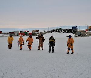 Six expeditioners walk on the sea ice