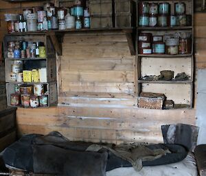 An historic bed on top of crates in a wood paneled hut