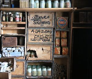 Tins of preserved food on a shelf of wooden crates