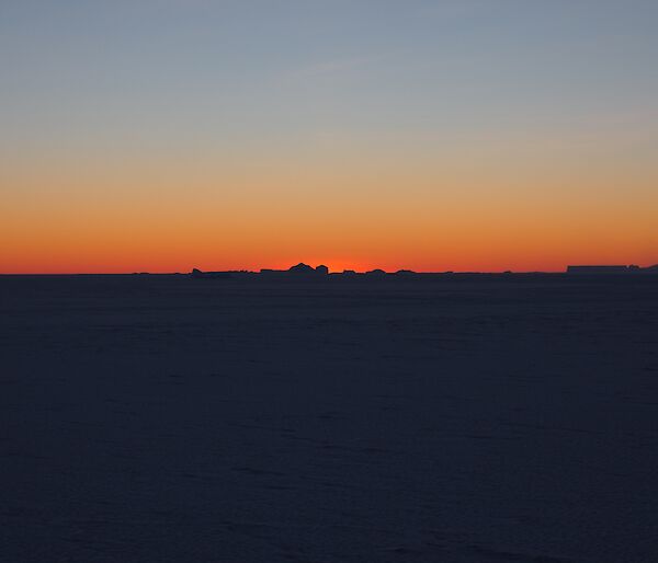 An orange Sunrise over the sea ice at Mawson