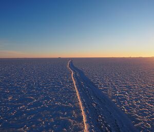 A tide crack in the ice is highlighted by the sunrise