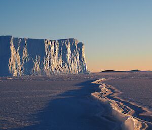 A pressure ridge of ice leads to an iceberg