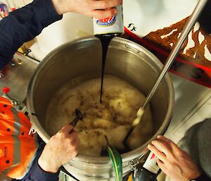 A pot of beer is being stirred.