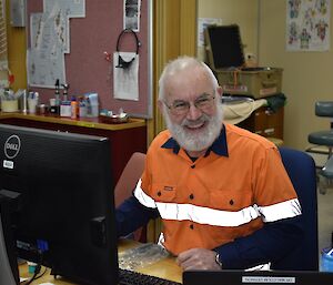 A man sits at a desk in an office.