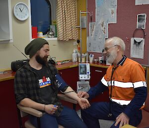 A doctor is measuring the blood pressure of a man.