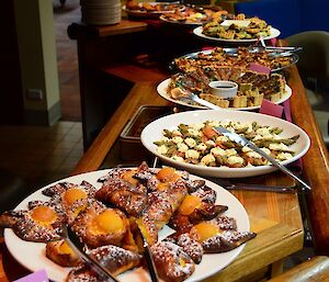 A bar is filled with platters of pastries.