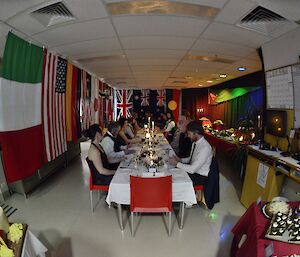A long table formal dinner room surrounded by flags