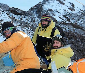 Three men in yellow freezer suits check out the radio repeater.