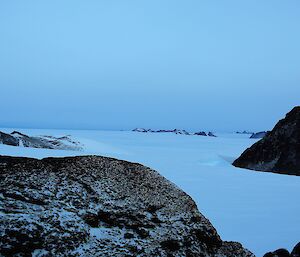 Mountain peaks poke out of a frozen plateau.