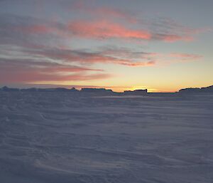 A frozen landscape and pink clouds.