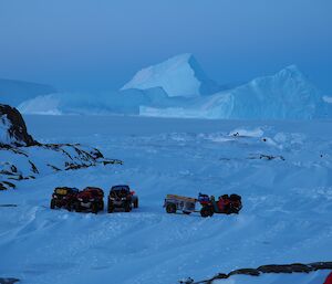 Four quad bikes sit on ice surrounded by towering icebergs