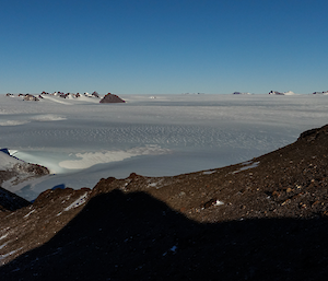 A panoramic shot of mountain peaks above an icy plateau