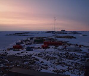 A pink sky overlooking snow covered Mawson station
