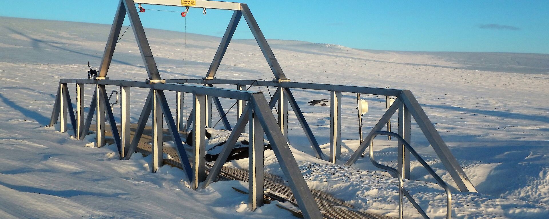 A metal framed pontoon above an icy plateau.