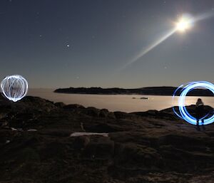 two circular orbs appear on an island with sea ice in the background