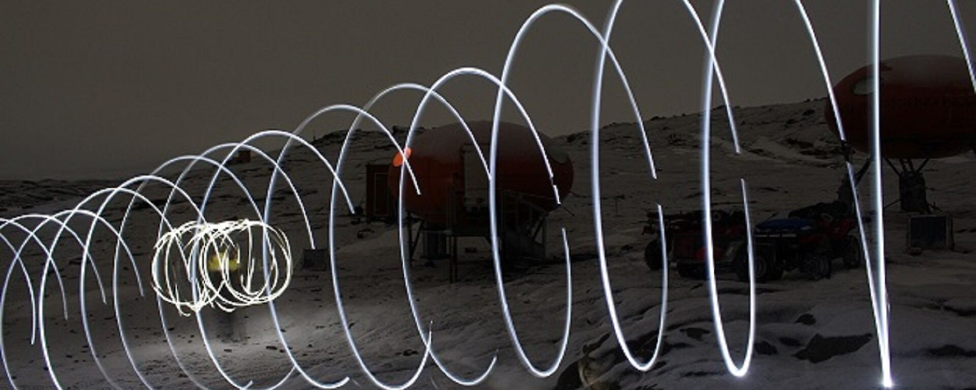 Light swirls appear across a snowy landscape