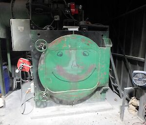 A green incinerator machine with a smiley face.
