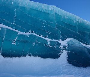 A jade green iceberg with layers of green and blue coloured ice.