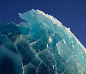 Sunlight shines through the peak of a jade iceberg.