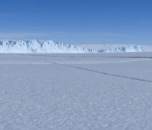 An ice cliff edge of the Antarctic plateau meets the sea ice.