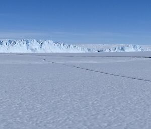 An ice cliff edge of the Antarctic plateau meets the sea ice.