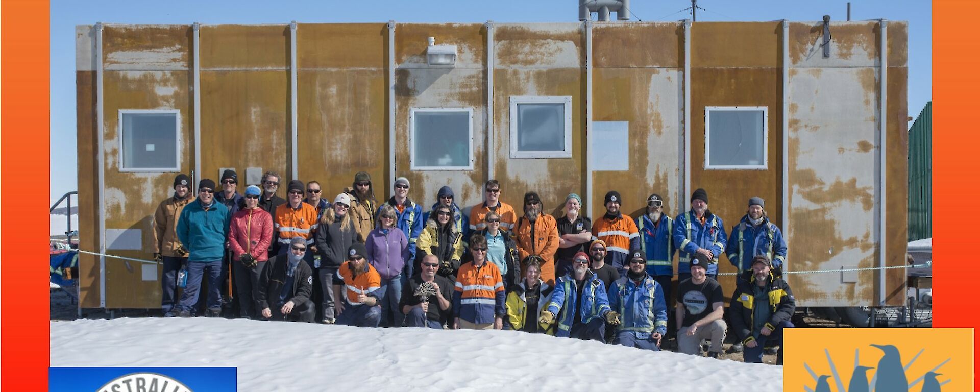 A group of 27 people stand in front of a brown building. The photo is set in a Christmas greeting card
