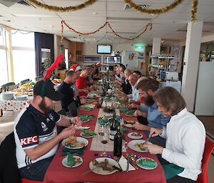 A group of people sitting around a long table eating lunch