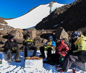 A group of people sitting around a meal in the snow