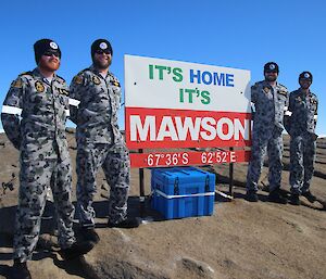4 Navy personnel smiling at the Mawson sign