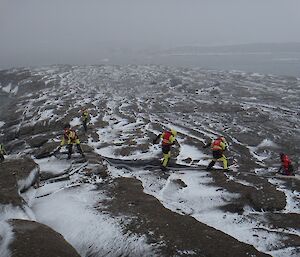 A group of people hauling a rope across the rocks