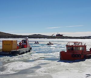 A barge, small tug and 2 IRBs involved in ice breaking work in the Harbour