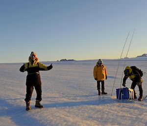 3 men on the plateau checking an emergency cache